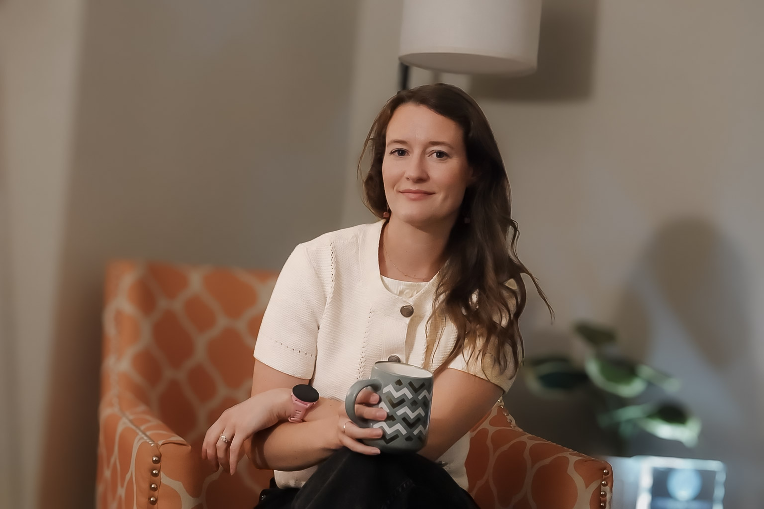 Mariah Stout, LCSW, seated in a warm office setting with a mug